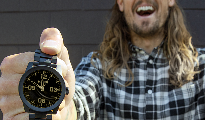 A man holds up the Nixon Corporal Quartz watch